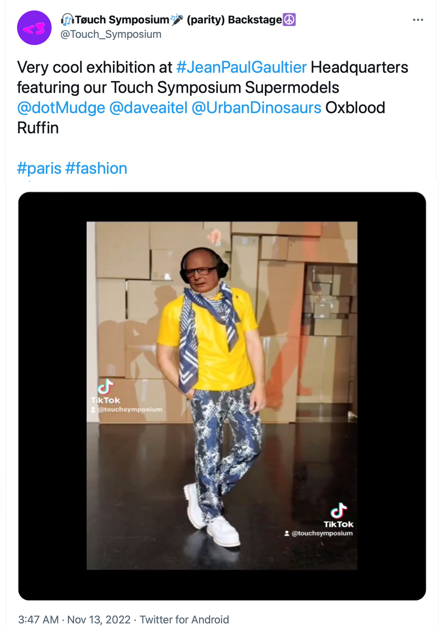 13 Nov 2022 tweet from @Touch_Symposium: A professionally-taken full-length photo of a male fashion model, but superimposed over the model's head is a crudely cut-and-pasted picture of Oxblood Ruffin's head. The text reads: 'Very cool exhibition at #JeanPaulGaultier Headquarters featuring our Touch Symposium Supermodels @dotMudge @daveaitel @UrbanDinosaurs Oxblood Ruffin #paris #fashion'